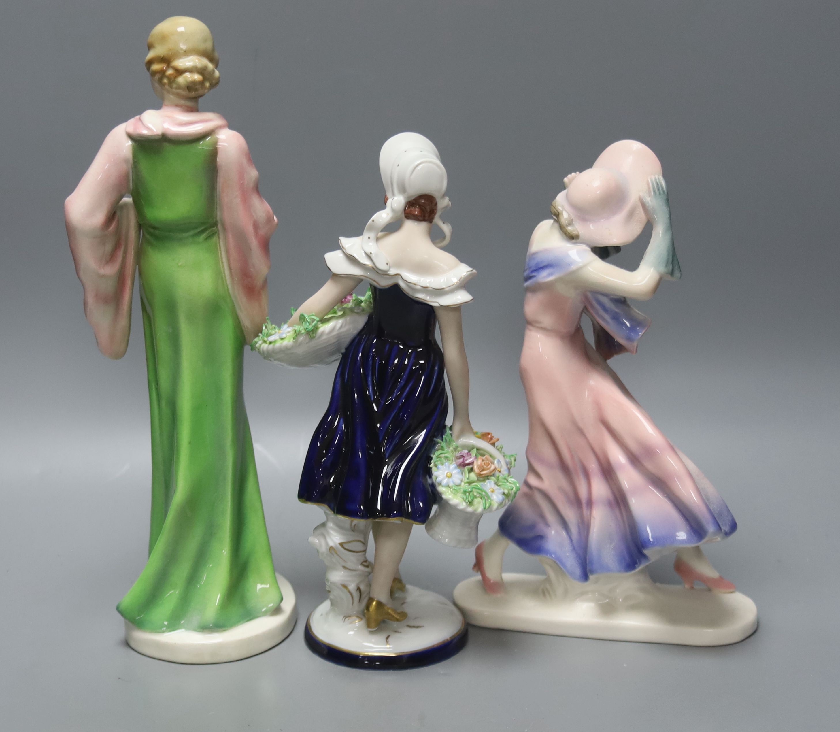 A Royal Dux figurine of a flower girl, height 26cm and two other figurines